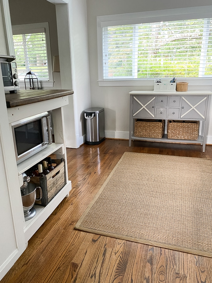 Natural jute rug on hard wood floors in dining area.