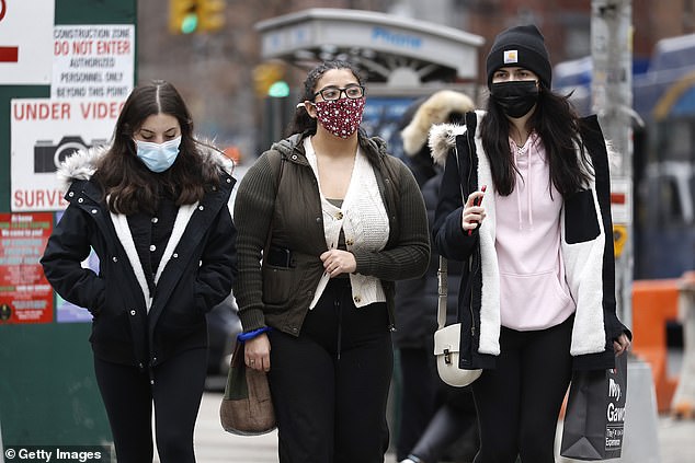 Women are seen wearing face masks in New York City on Wednesday
